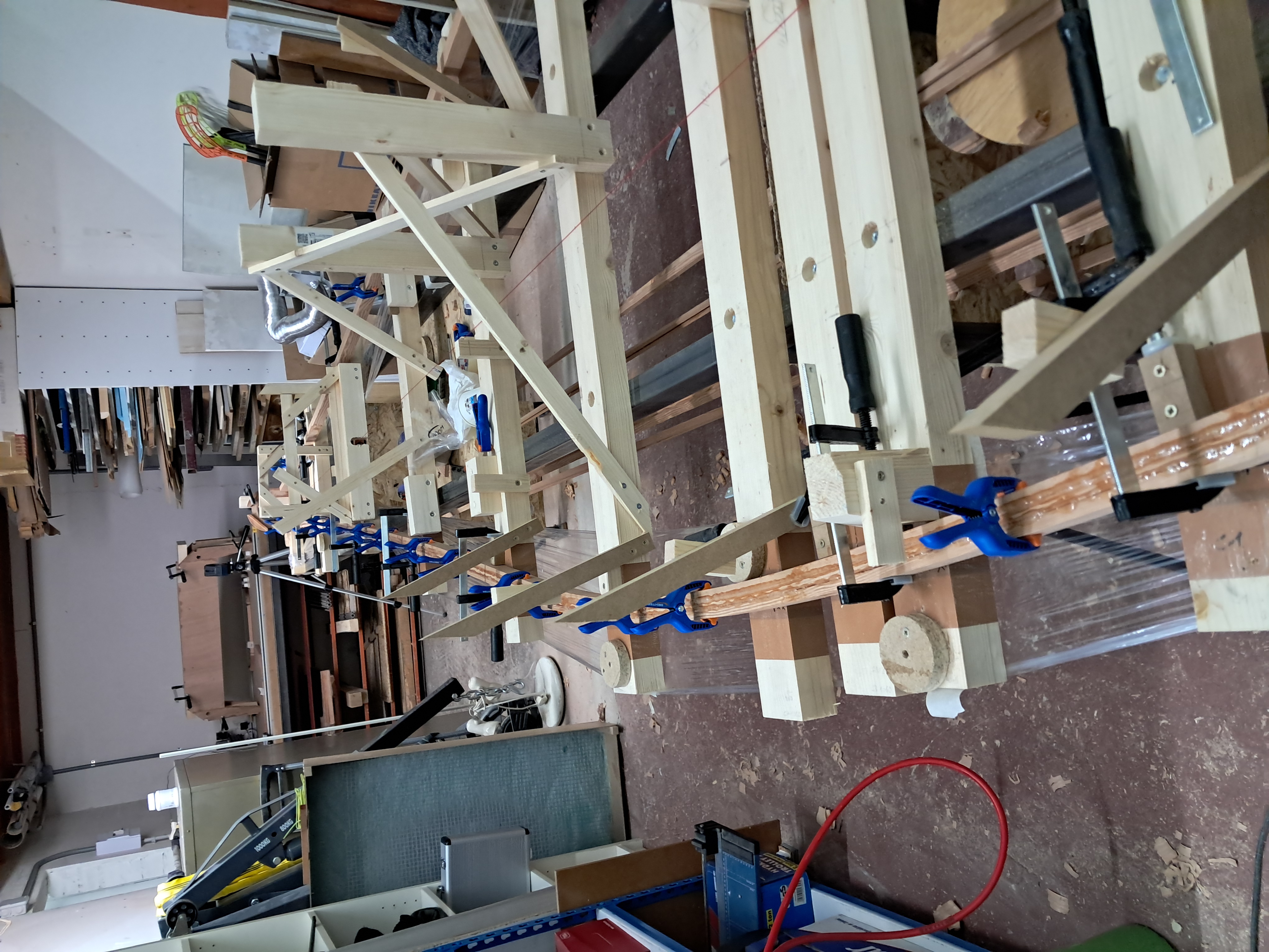 La première baguette 30x10 collée et maintenue en position sur le bâti de montage.